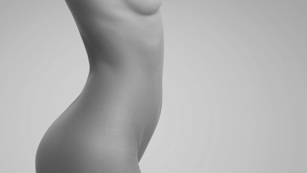 Imagen artística en blanco y negro de perfil lateral femenino con cintura y cadera estilizadas, representativa de los resultados de una liposucción WAL