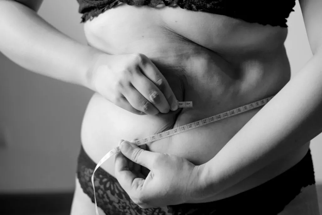 Woman pinching the skin of her abdomen