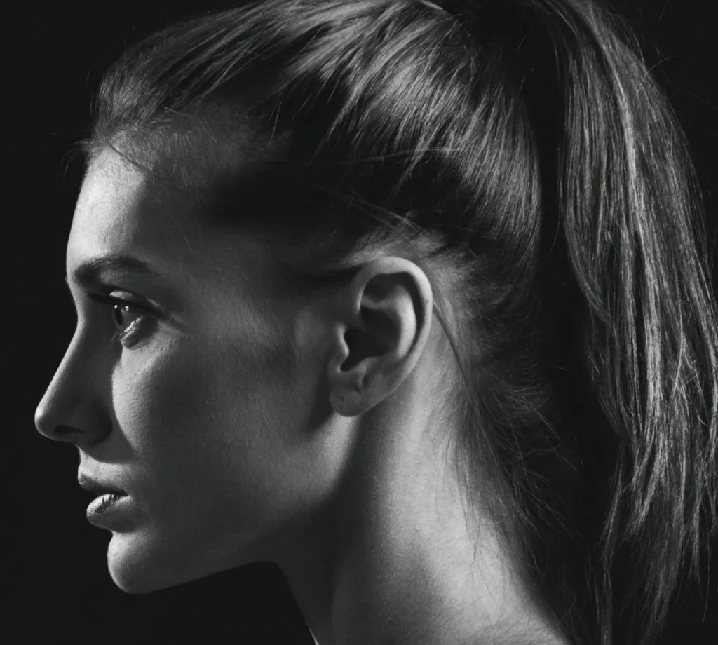 Perfil de una mujer con el pelo recogido y la oreja visible